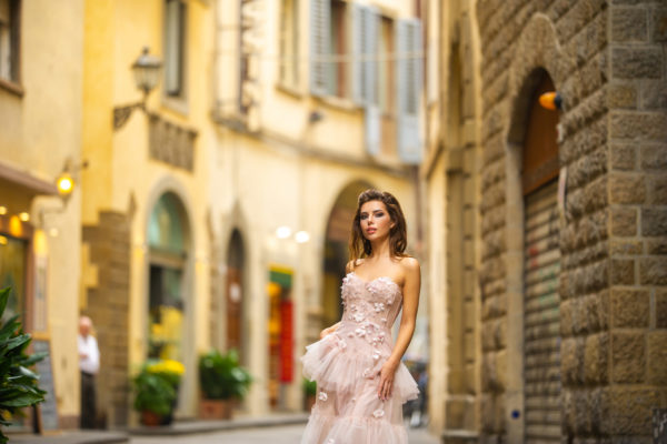 A bride in a pink wedding dress walks in Florence, Italy.